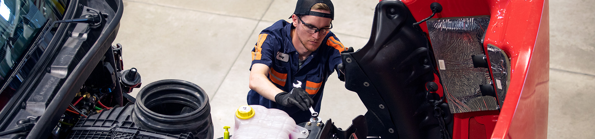Photo of technician working on truck engine